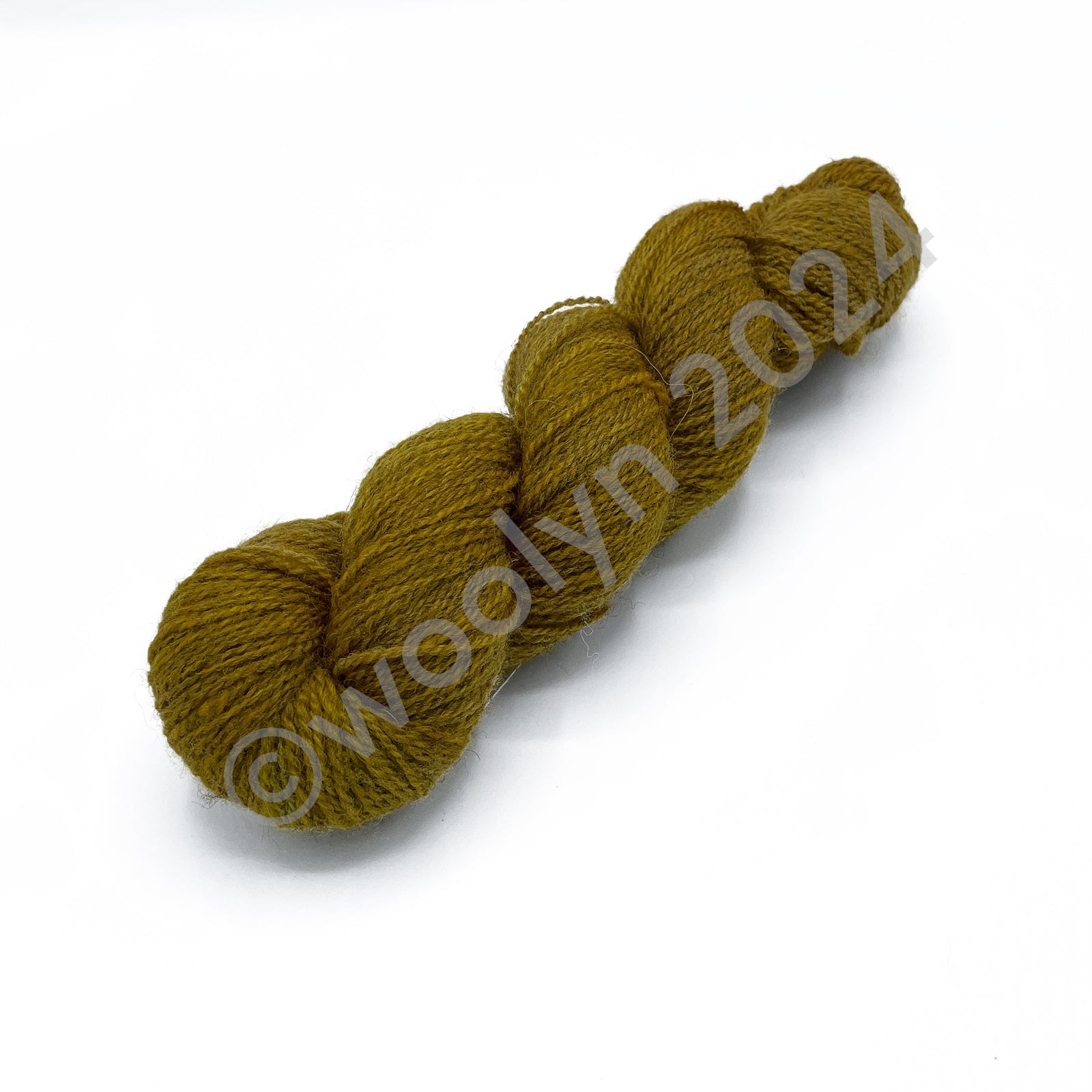 A skein of Woolerton Estates Farmhand Ada, a rich golden yellow with deep grey undertones.