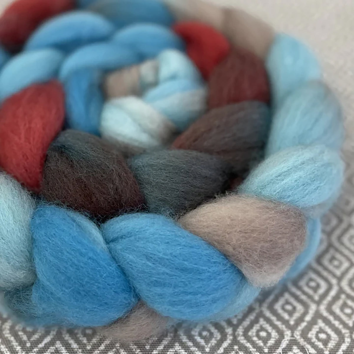 Detail of Greenwood Fiberworks Pigtails American Diner in shades of light blues, rust red, sand, and dark brown