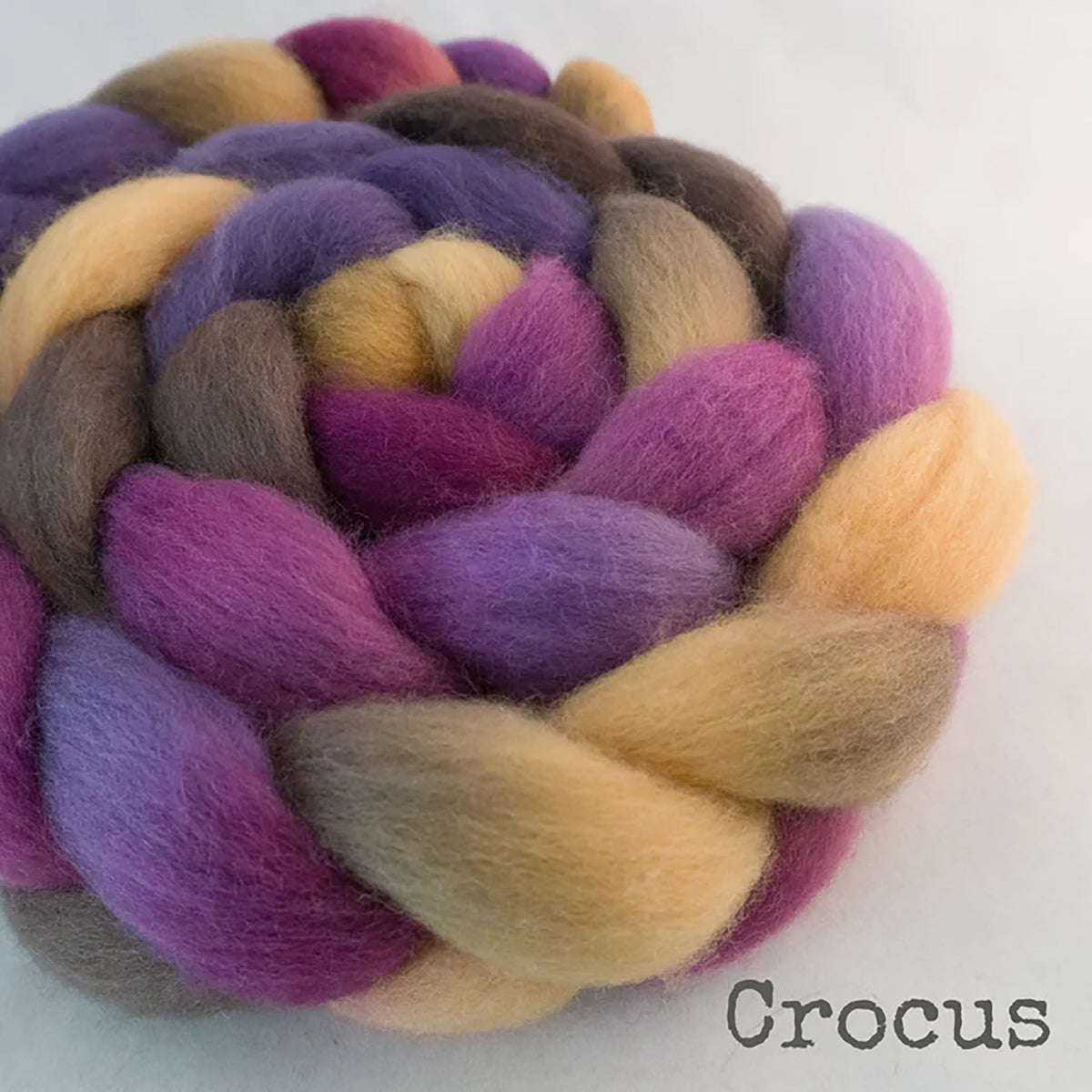 Detail of Greenwood Fiberworks Pigtails Crocus in colors plum purple, orchid purple, sandy yellow, and brown
