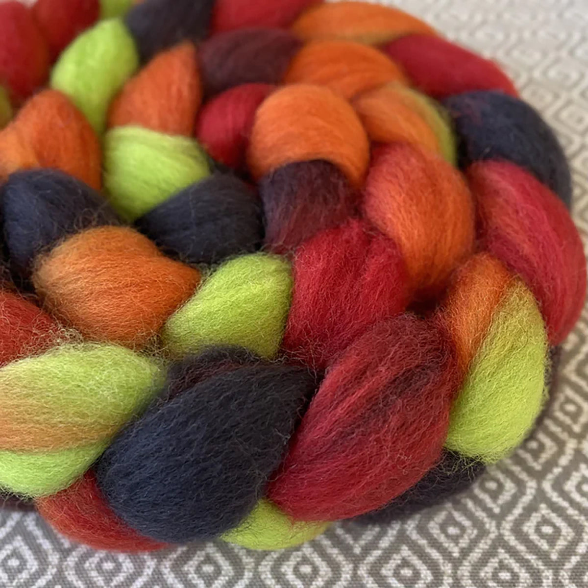 Detail of Greenwood Fiberworks Pigtails Dragon Scales in colors dark brown, lime green, ruby red and orange