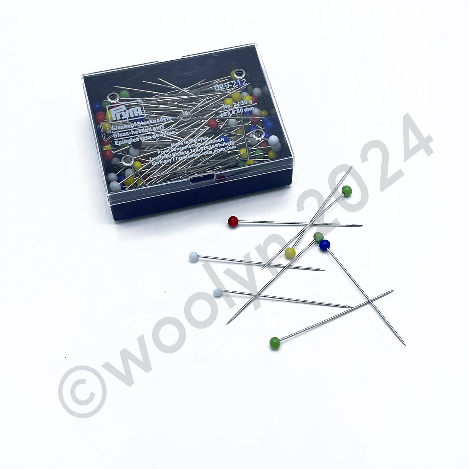 A plastic case of Prym metal pins with glass heads of various colors.