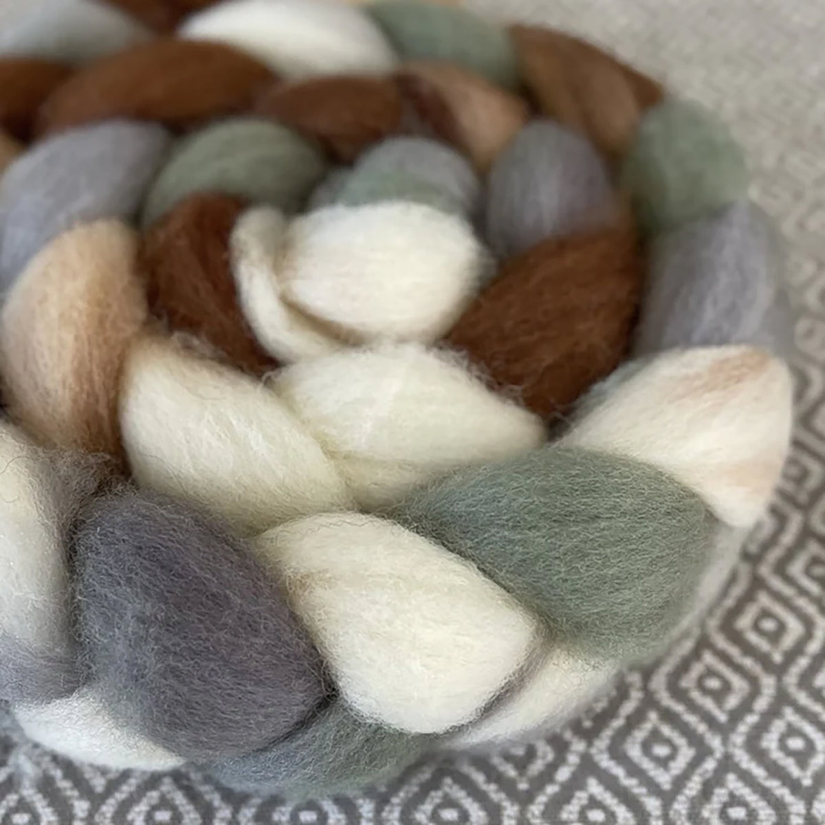 Detail of Greenwood Fiberworks Pigtails Hen House in colors cream, grey, sand, dark prawn, and earthy greens