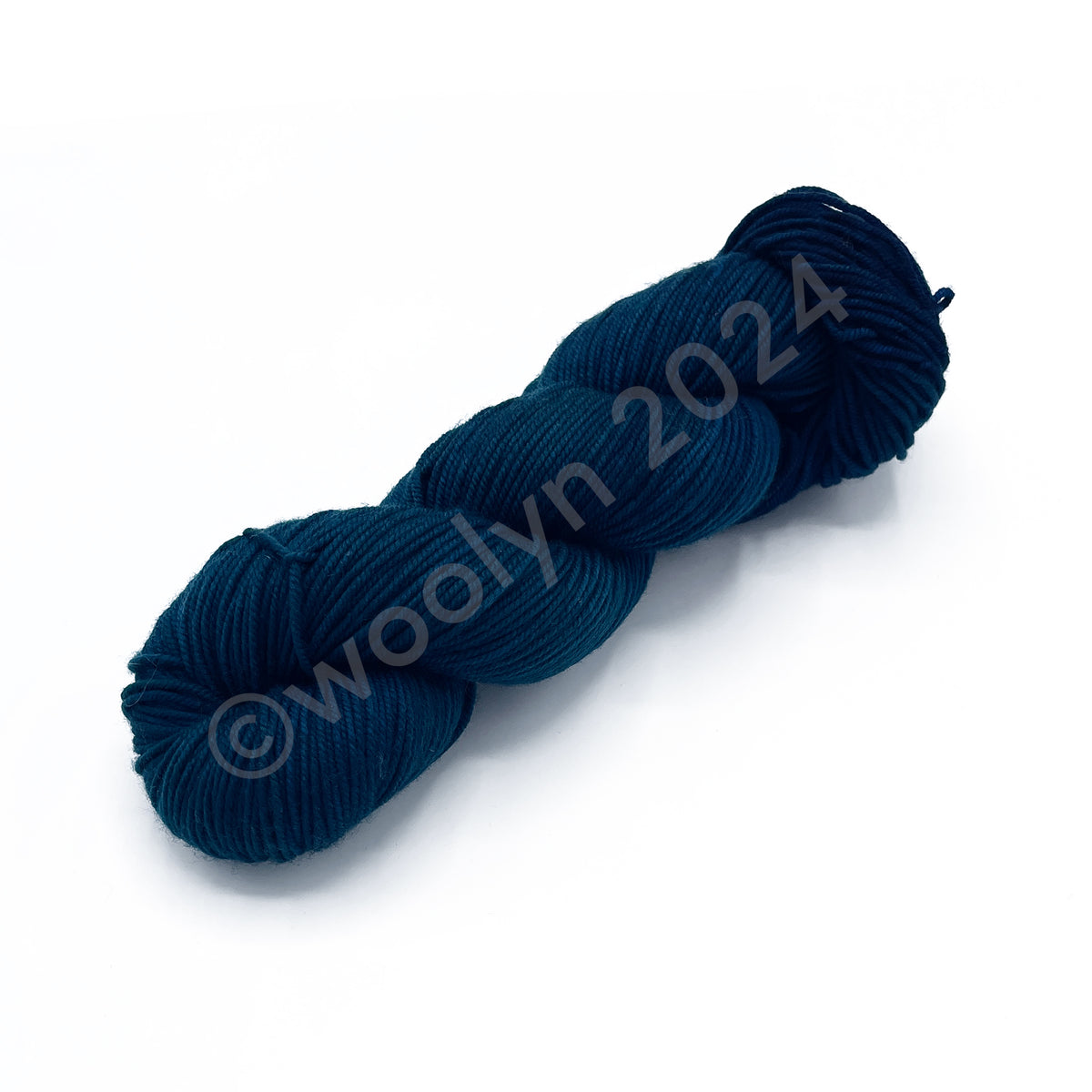A Skein of Knitted Wit DK Islands In the Storm, a dark teal blue