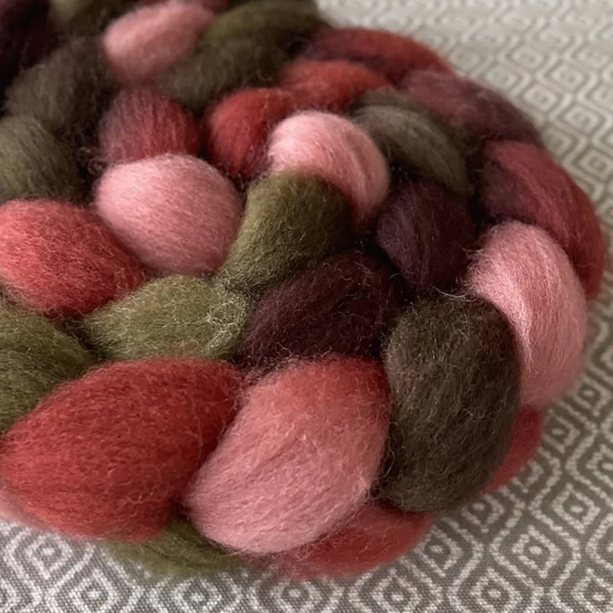Detail of Greenwood Fiberworks Pigtails Paper Roses in colors dusty pink, dark brown, rust red, and earthy green