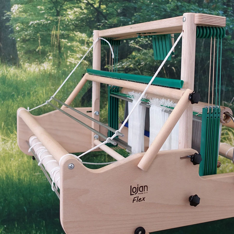 Rear view of the wooden Lojan Flex loom against a forest background showcasing the raddle attachment