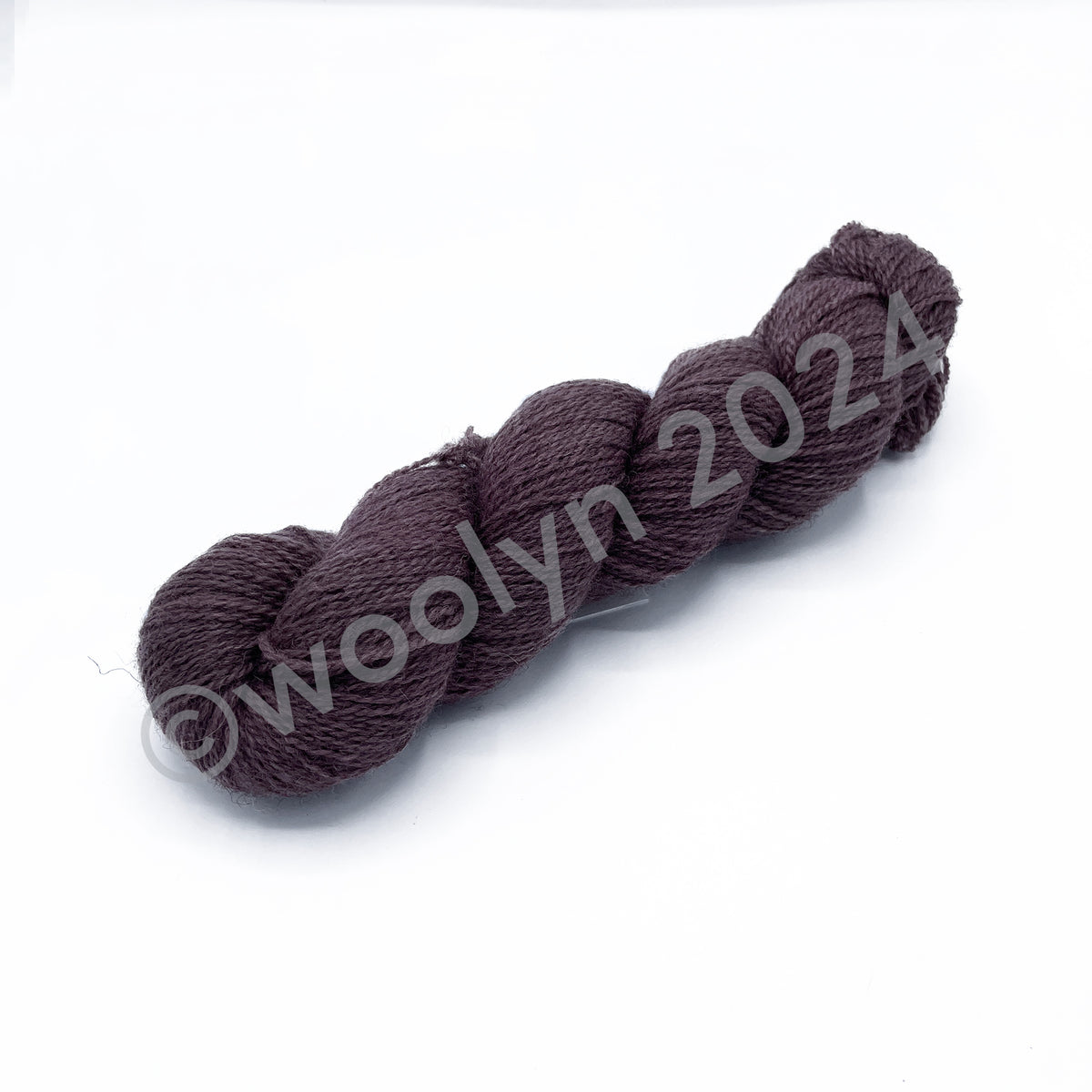 A skein of Woolerton Estates Farmhand Rupert, a dusty mauve color with grey undertones.