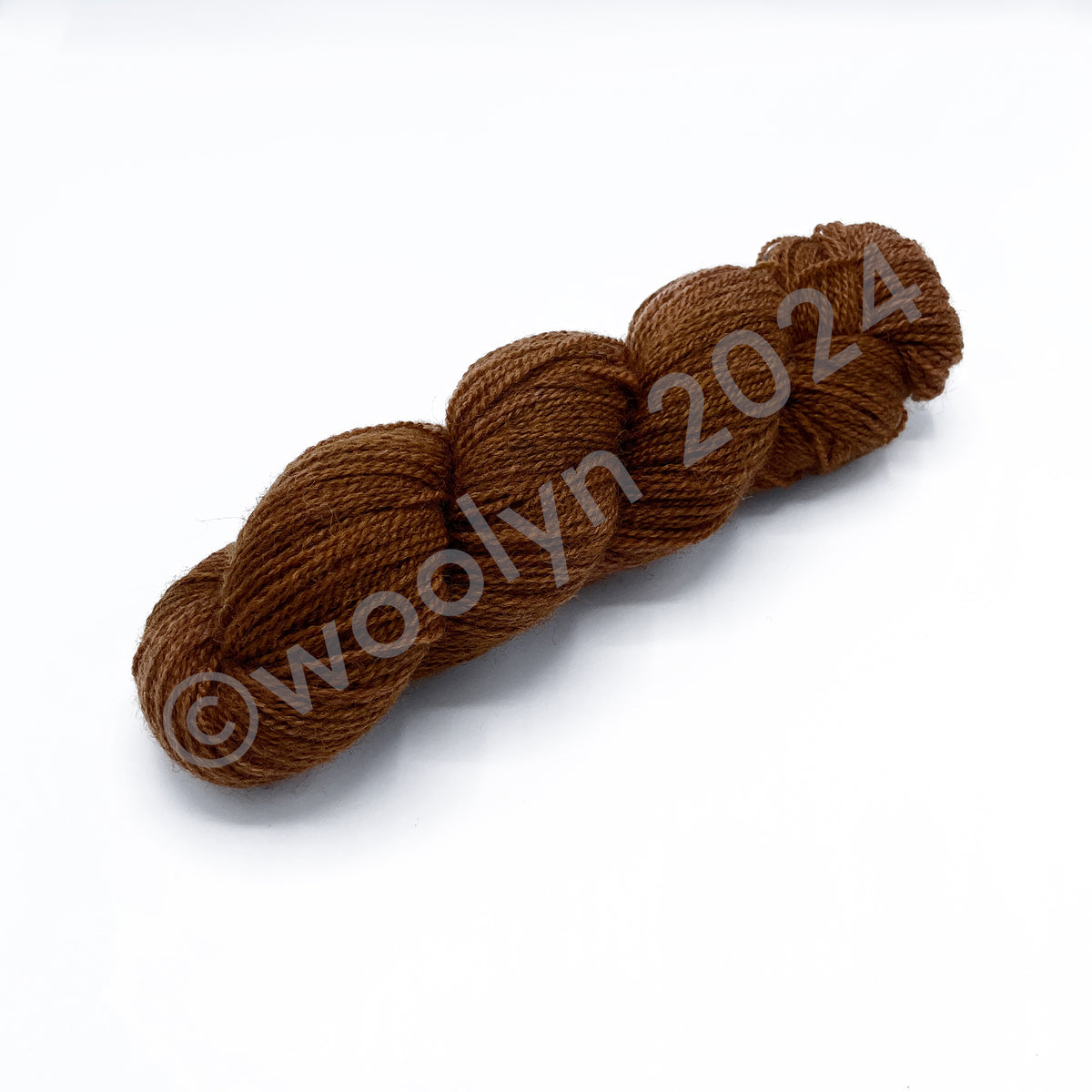 A skein of Woolerton Estates Farmhand Siobhan, a rusty orange color with grey undertones.