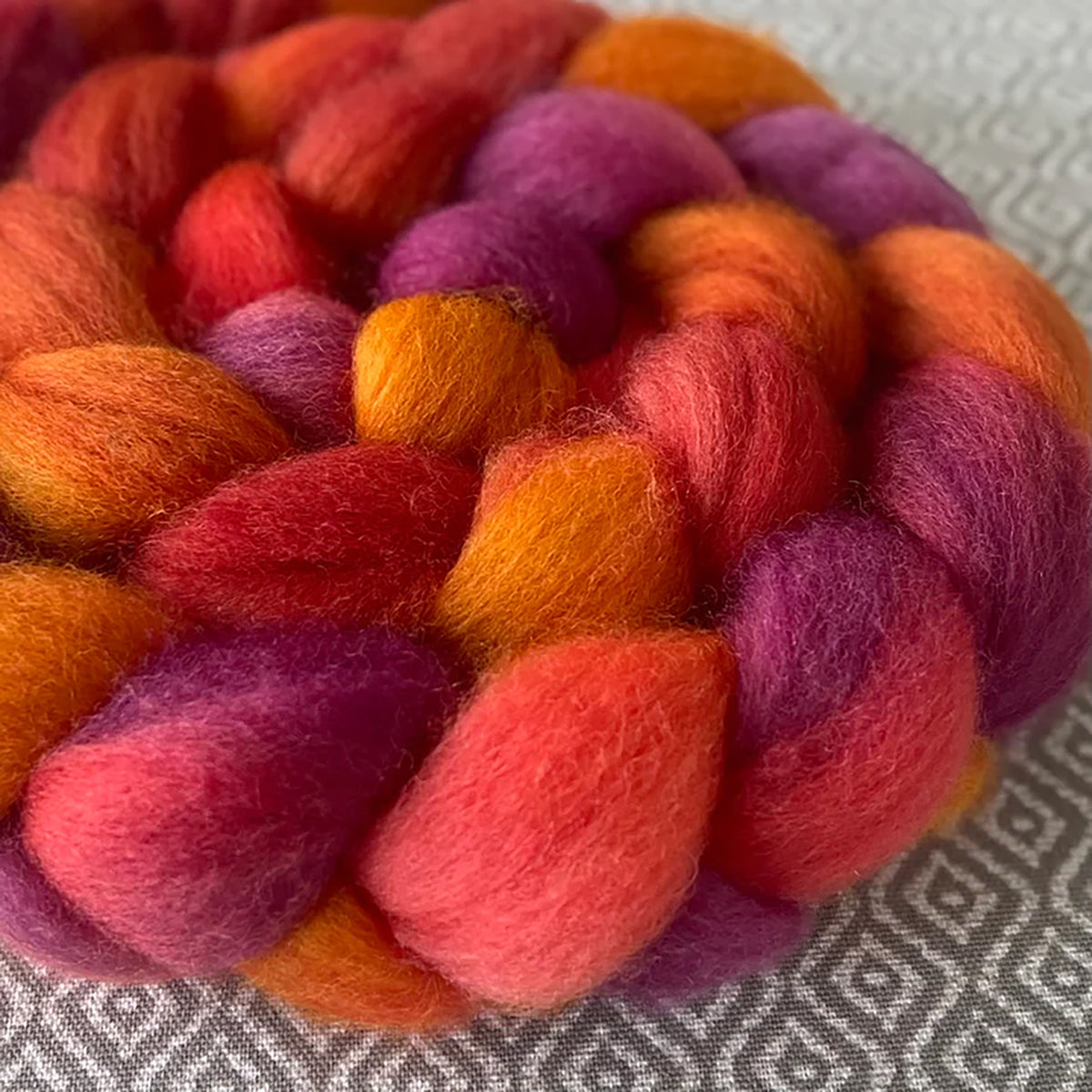 Detail of Greenwood Fiberworks Pigtails Topaz in bright warm toned red, pink, gold, and purple colors