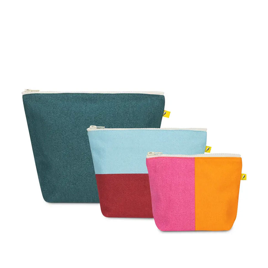 A set of three zippered pouches, a large teal pouch, a medium two-tones red and blue pouch, and a small two-toned pink and orange pouch on a white backgro7nd