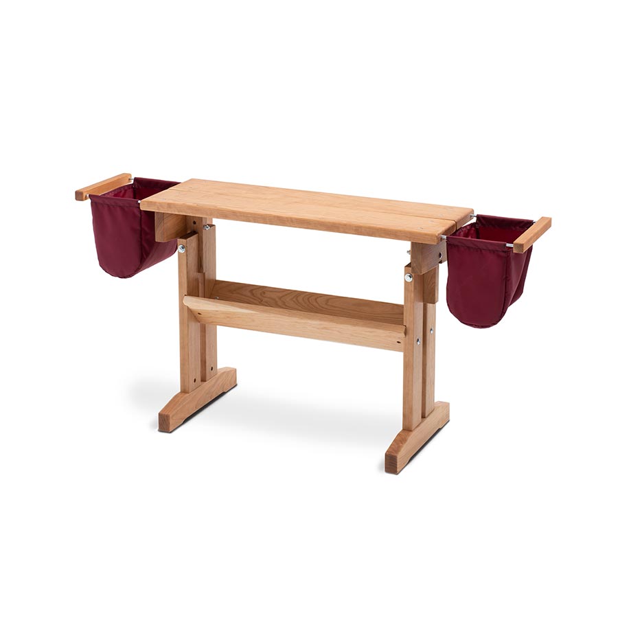Image of a cherry wood adjustable height Schacht Floor Loom Bench with add on red side bags. 