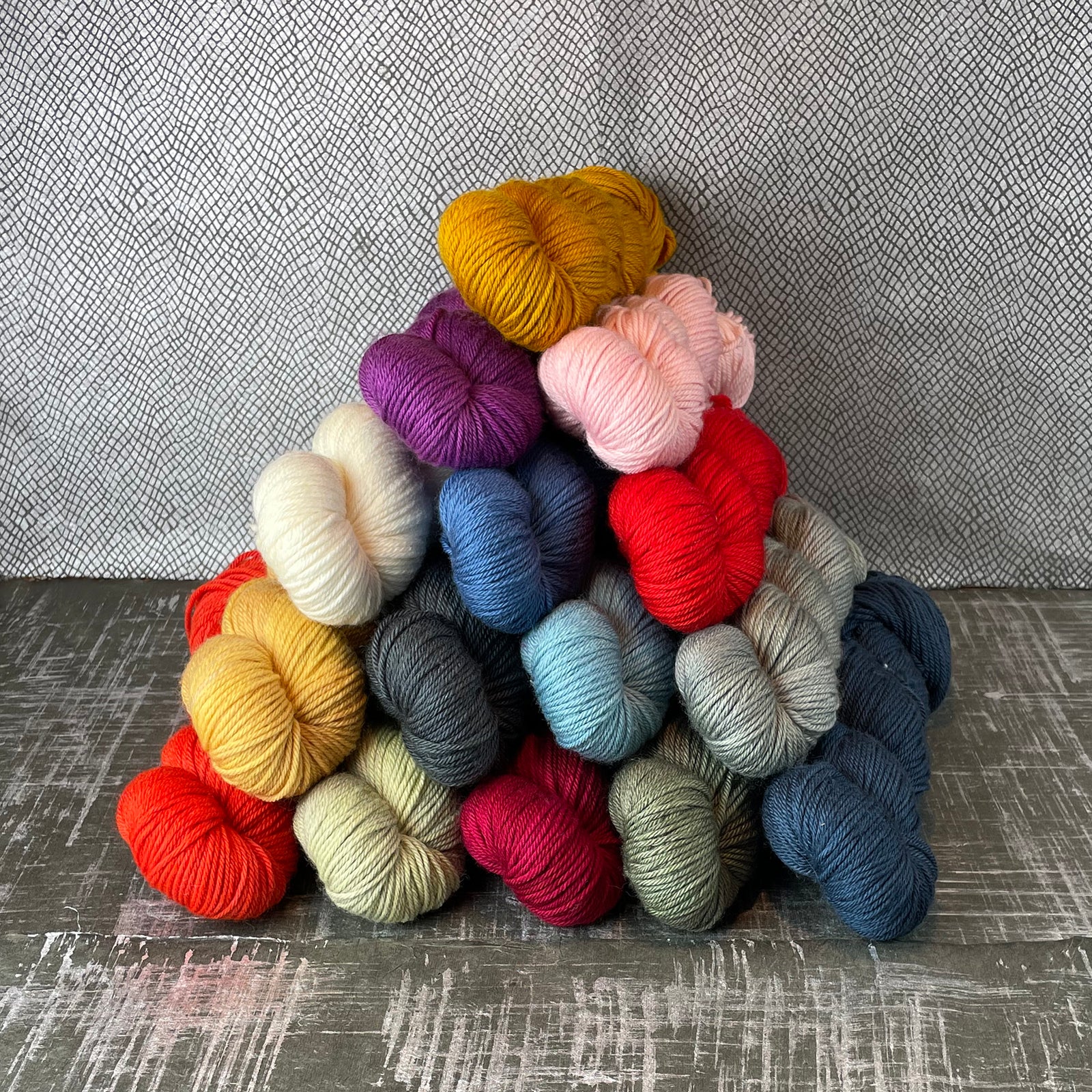 Skeins of Tesserae Kissa in different colors stacked in a pyramid shape