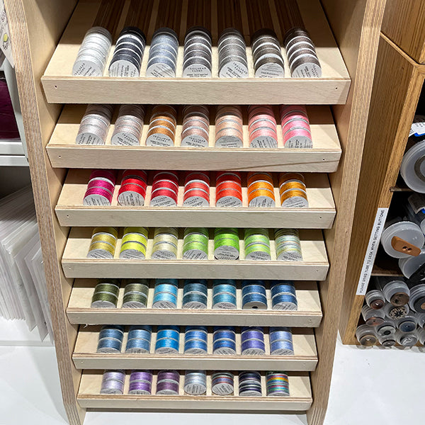 Trailhead Yarns Acorn thread bobbins in display in a rainbow of colors