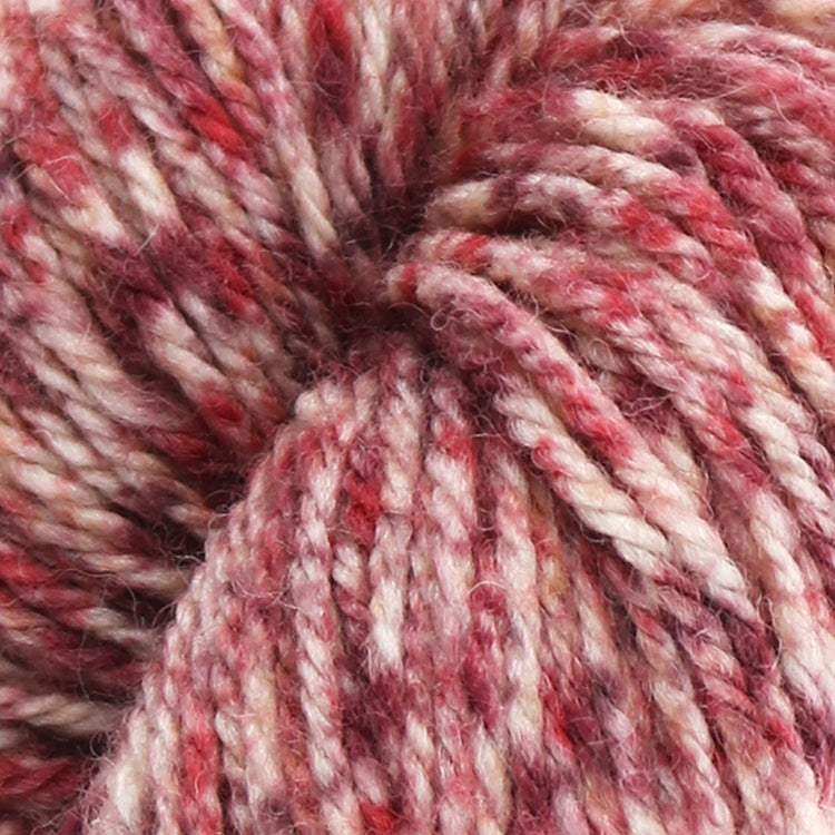 West Yorkshire Spinners the Croft Shetland Tweed in Copister a white base yarn with red and maroon speckle.