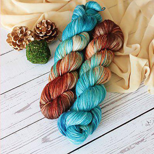 Yarn Love Amy March in Copper Canyon a variegated yarn in turquoise, teal, brown and sunset orange.