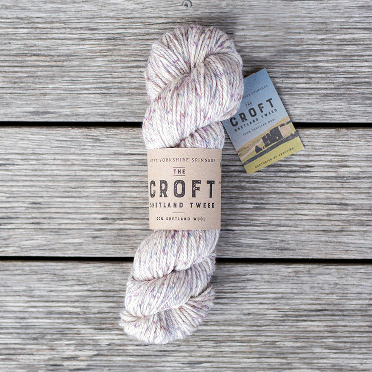 West Yorkshire Spinners the Croft Shetland Tweed in Clousta a white based yarn with lavender and blue speckle.