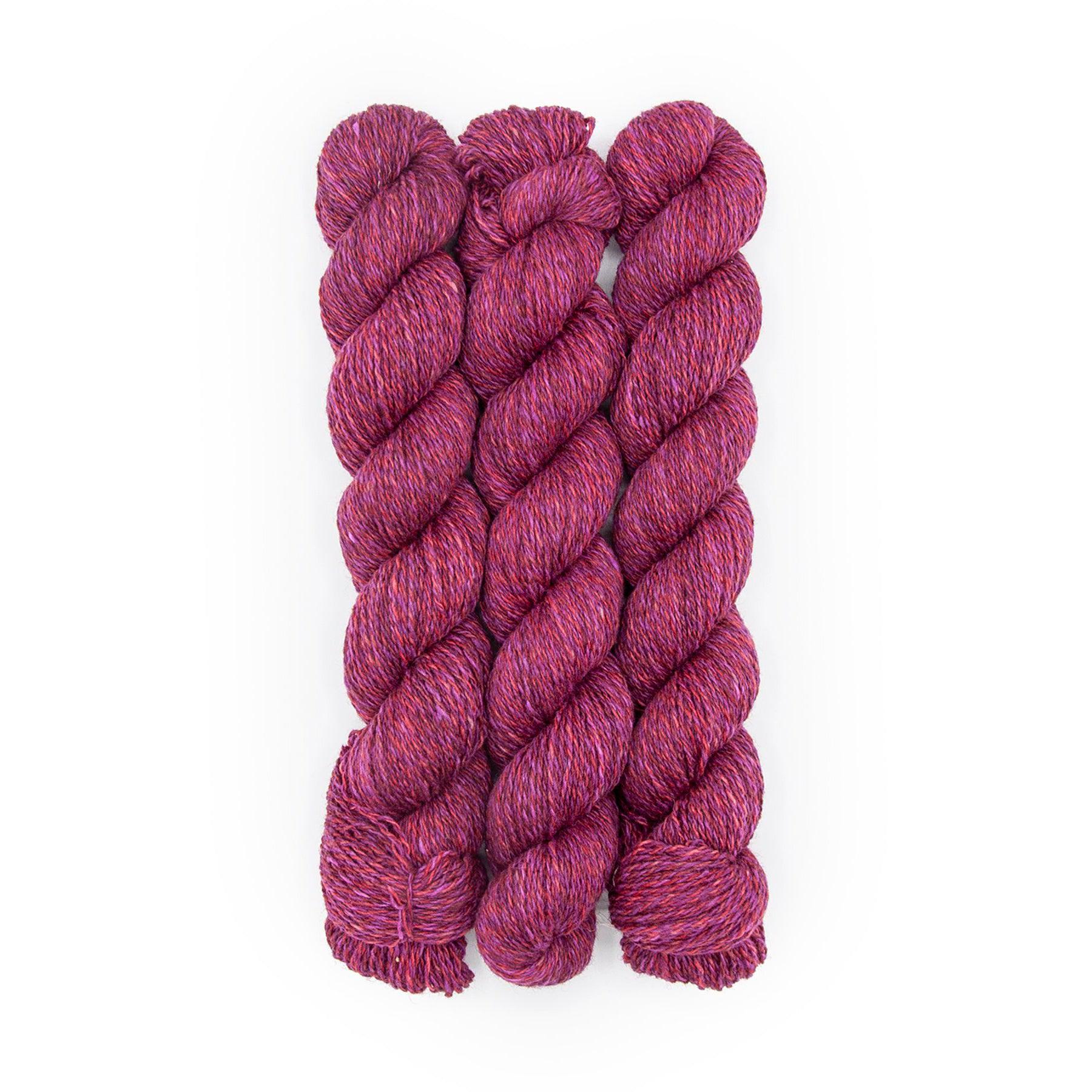 Plied Yarn North Ave Divine a marled yarn with pink, violet and maroon colors.