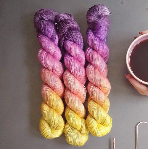 Yarn Love Amy March in Flower Market a gradient yarn in yellow, coral, pink and purple. 
