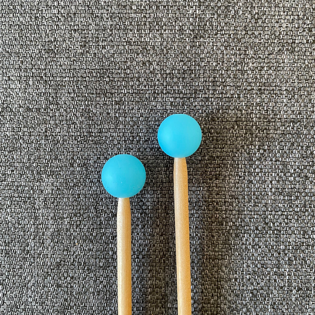 Two knitting needles topped with blue gumball Stitch Stoppers