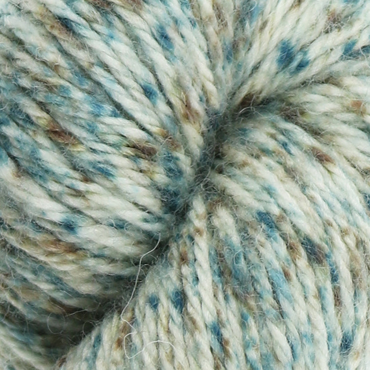 West Yorkshire Spinners the Croft Shetland Tweed in Hillswick a white base yarn with turquoise and brown speckle.