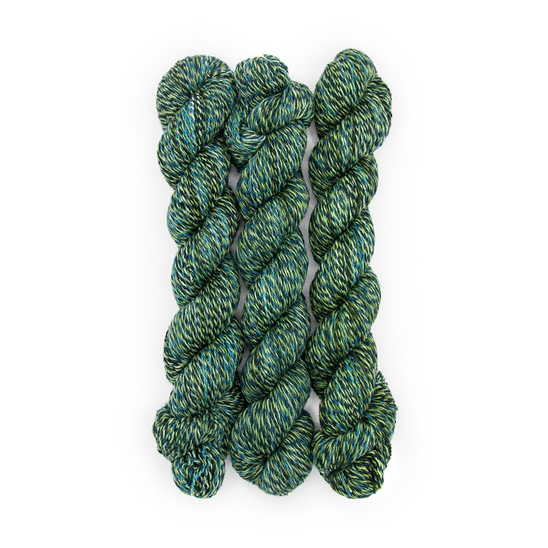 Plied Yarn North Ave Tree Baltimore a marled yarn with moss green, navy, bright blue and black colors. 