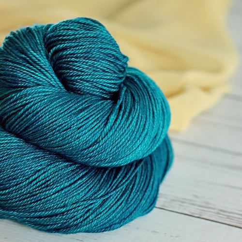 Yarn Love Amy March in Verdigris a solid turquoise yarn.