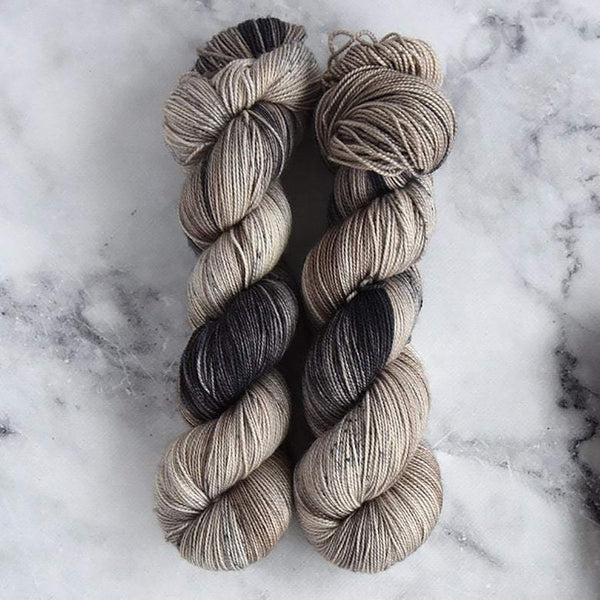 Skeins of Destination Yarn Passport Montmartre, a variegated yarn with warm shades of taupe, cream and dark brown.