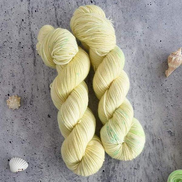 Skeins of Destination Yarn Souvenir Pineapple, a light yellow with minimal pale green speckling.