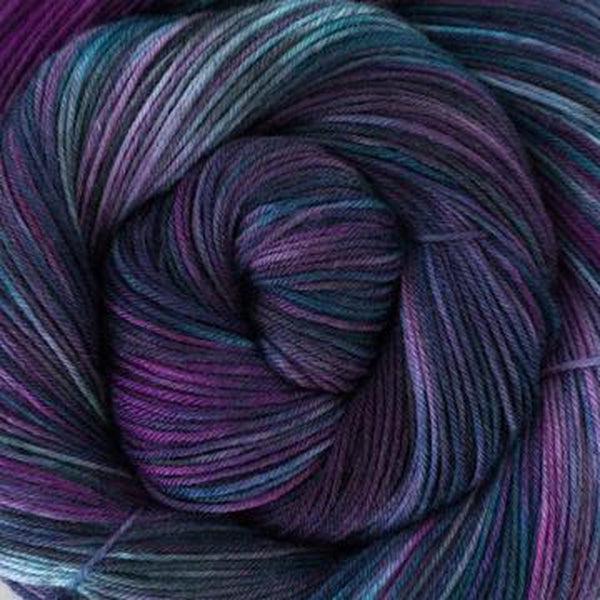 Detail of Greenwood Fiberworks Simply Sock , a variegated yarn in shades of purple, dark blue and hints of light blue.
