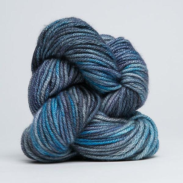 Skein of Jade Sapphire Cashmere 8Ply Bluestone 160, a gently variegated yarn in tonal shades of blue.