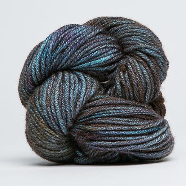 Skein of Jade Sapphire Cashmere 8Ply Primordial 175, a gently variegated yarn in shades of dark blue, green and brown.