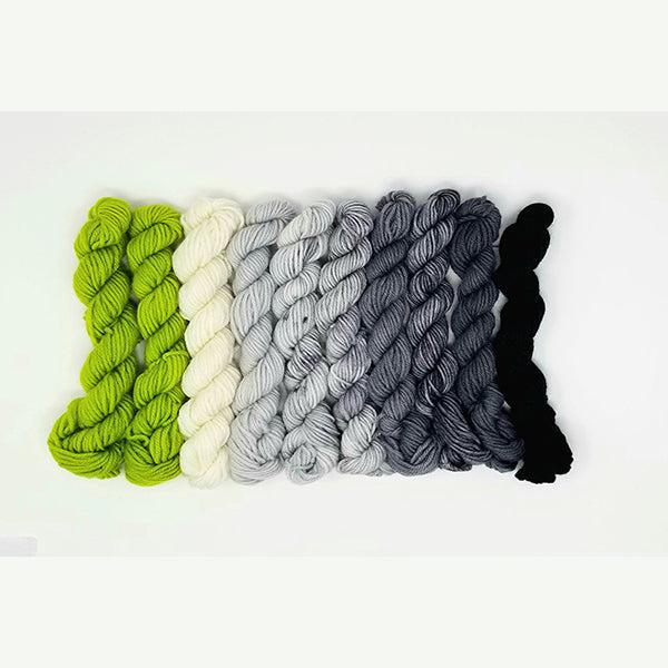 10 mini skeins of Jade Sapphire Coloring Box Big Apple Green- and pattern booklet in shades of bright green, natural, greys and black.