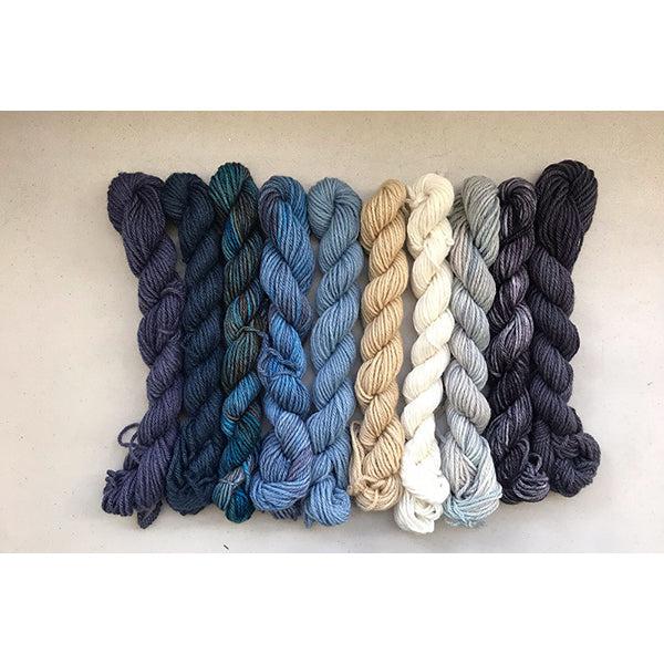 10 mini skeins of Jade Sapphire Coloring Box Dungaree-and pattern booklet in shades of natural, grey, blues and black.