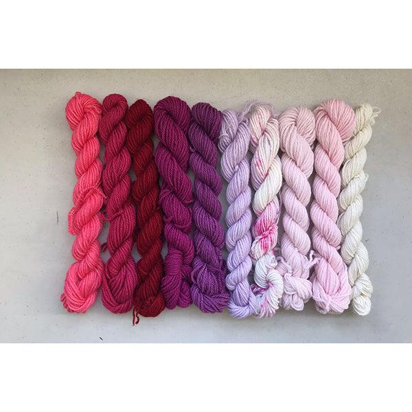 10 mini skeins of Jade Sapphire Coloring Box I ♥ You- and pattern booklet in a gradient from natural,  pinks and purples from light to dark. 