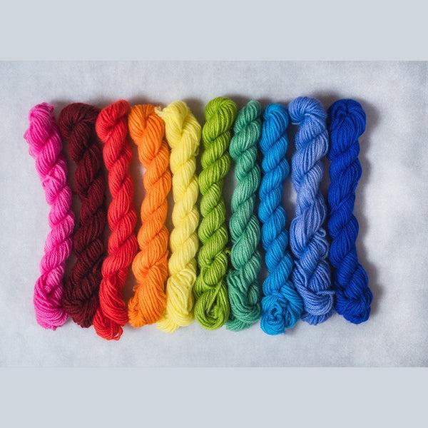 10 mini skeins of Jade Sapphire Coloring Box Madcap-and pattern booklet in a rainbow gradient. 