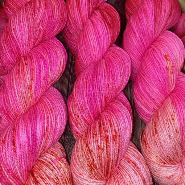 Skeins of JEMS Monster Minis Apples of Discord, a variegated yarn in shades of pink. 