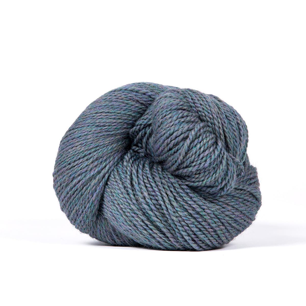 A skein of Kelbourne Woolens Camper Blue Heather 425, a heathered steely blue.