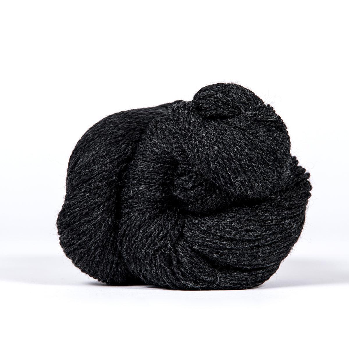A skein of Kelbourne Woolens Camper Charcoal Heather 028, a heathered dark grey.