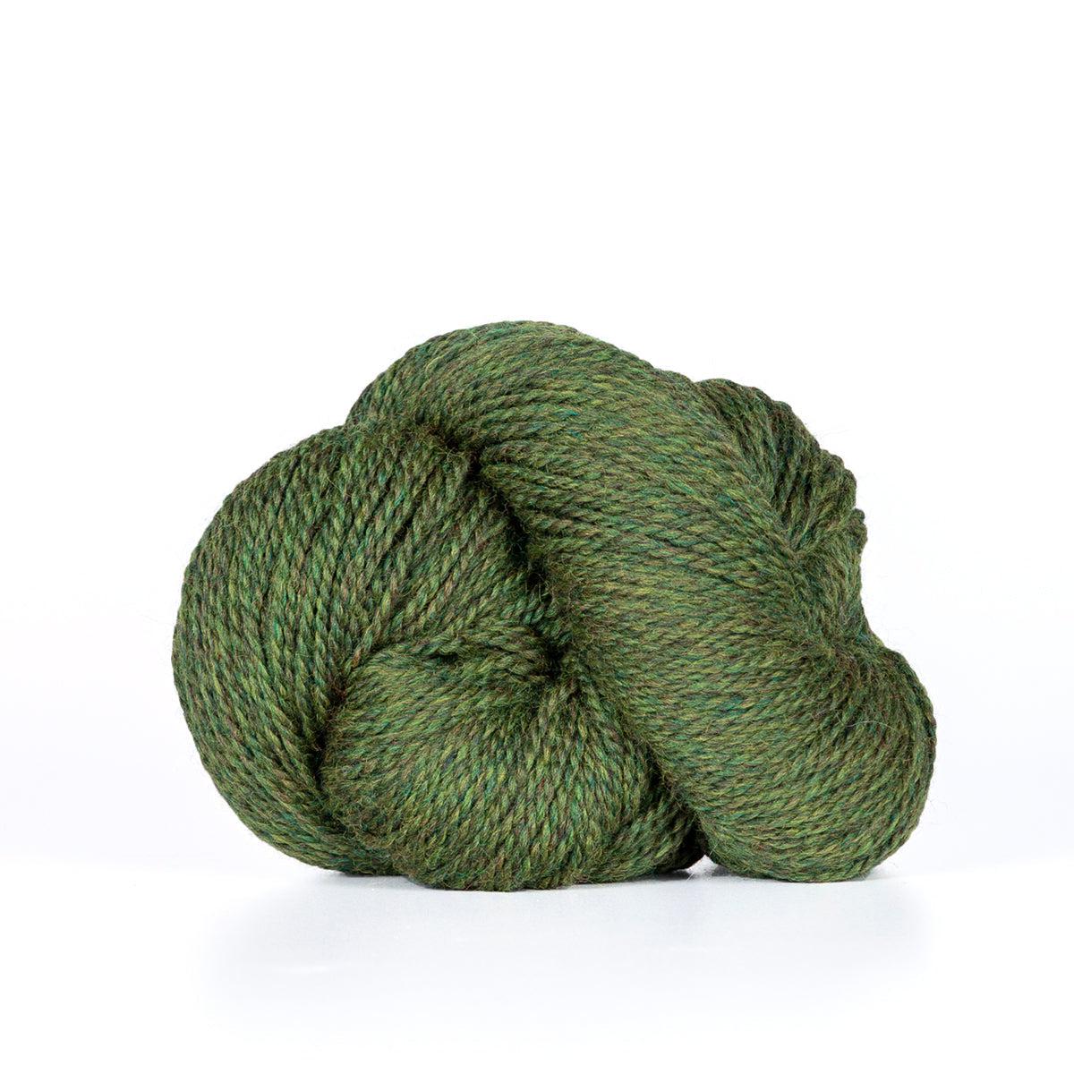 A skein of Kelbourne Woolens Camper Moss Heather 305, a heathered dark yellowy green.