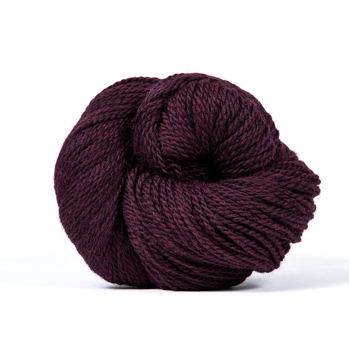 A skein of Kelbourne Woolens Camper Mulberry Heather 602, a heathered dark berry purple.