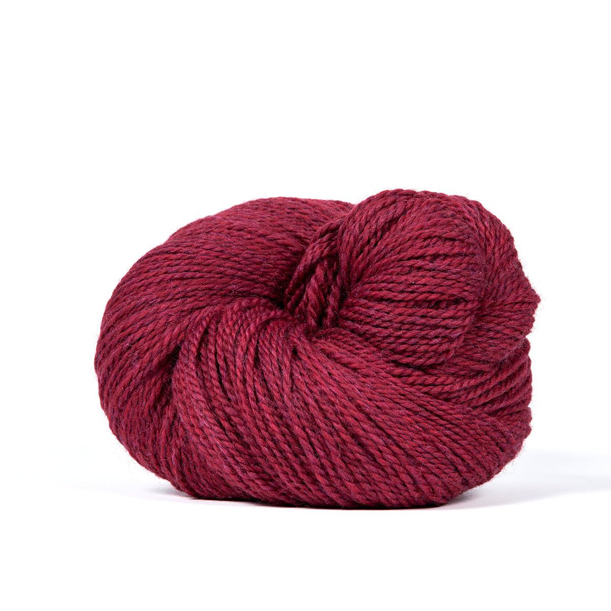 A skein of Kelbourne Woolens Camper Scarlet Heather 614, a heathered dark red.