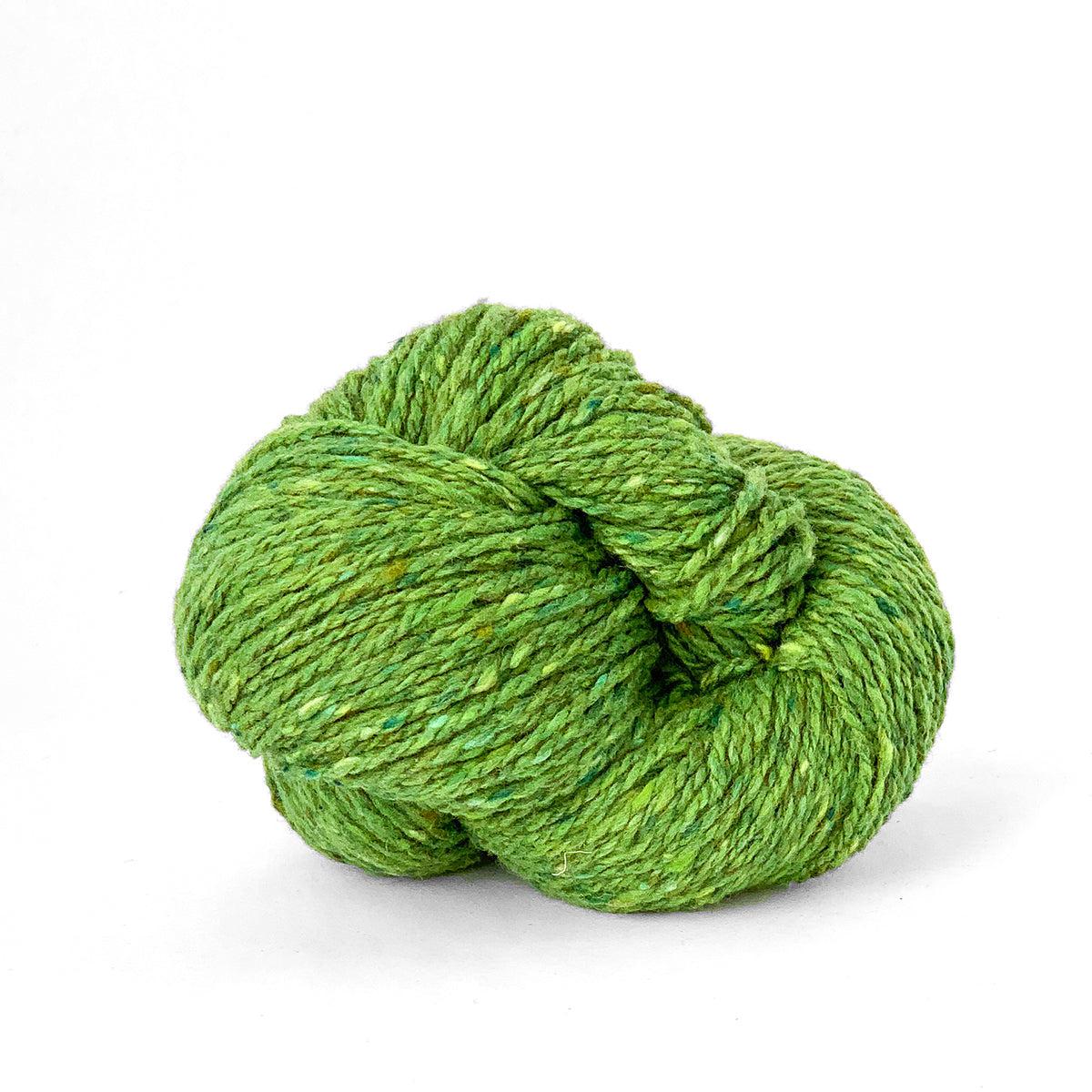A skein of Kelbourne Woolens Lucky Tweed Sprout, a bright spring green with yellow and darker green flecks.