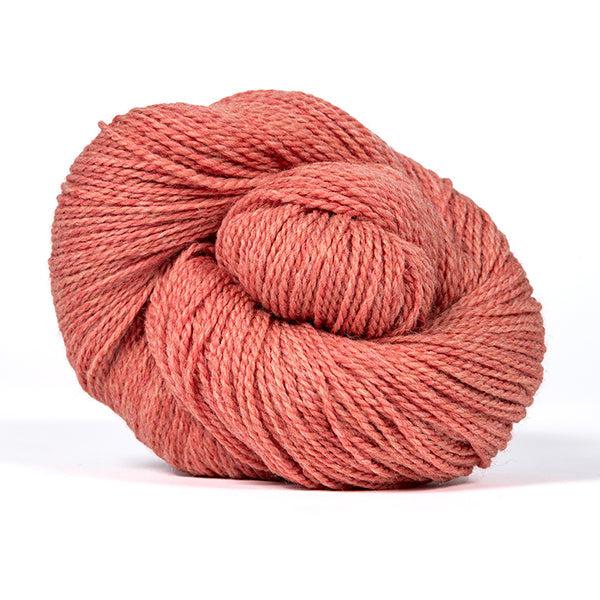 A skein of Kelbourne Woolens Scout Coral Heather 667, a heathered melon pink.