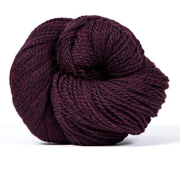 A skein of Kelbourne Woolens Scout Mulberry Heather 602, a heathered dark mulberry purple.