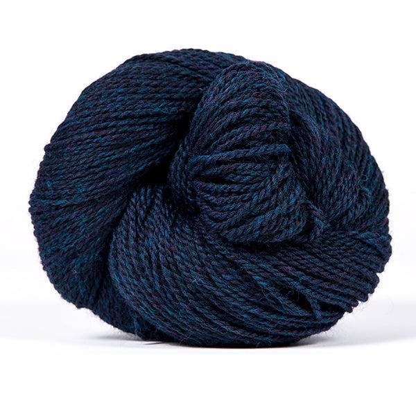 A skein of Kelbourne Woolens Scout Navy Heather 412, a heathered navy blue.