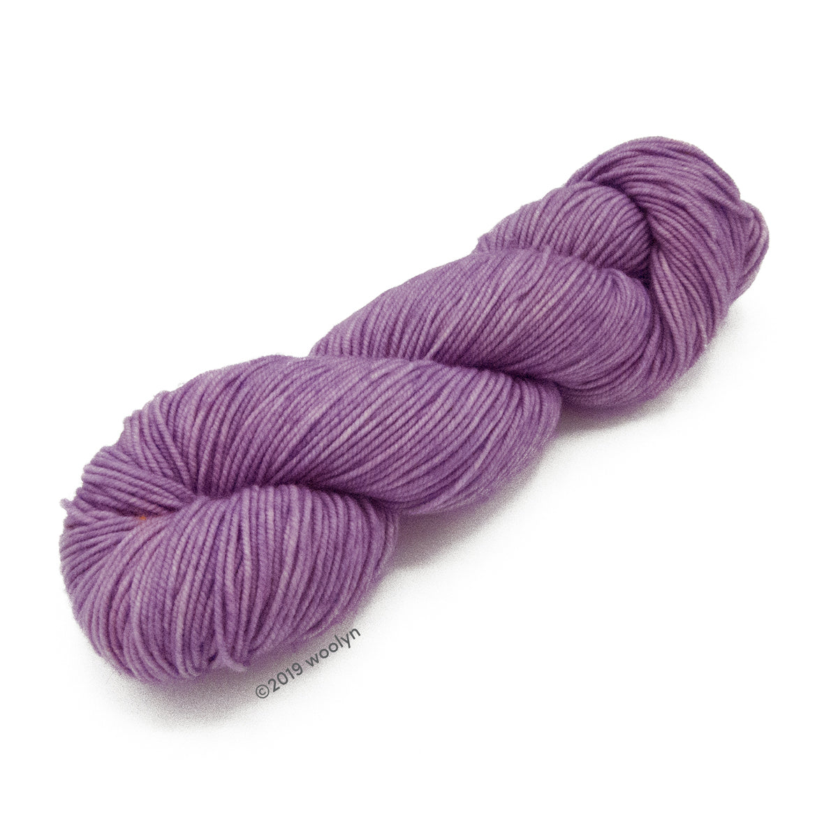 A skein of Knitted Wit Victory DK in Hydrangea a solid light purple color.