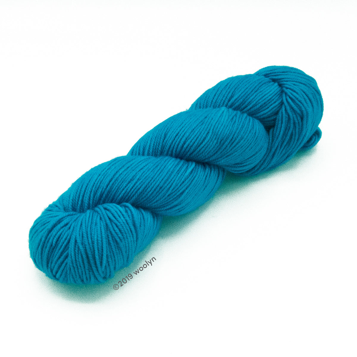 A skein of Knitted Wit Victory DK in Turks and Caicos a bright blue color.