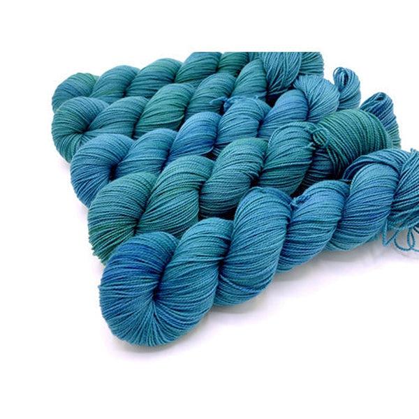 Skeins of Murky Depths Deep Sock Baja, a bright blue green color with lots of tonal variation. 
