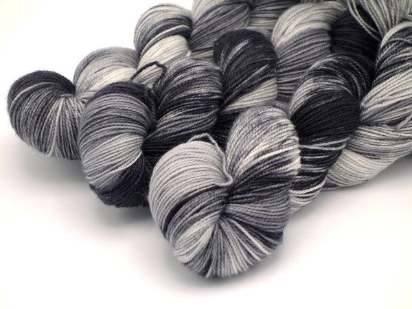 Skeins of Murky Depths Deep Sock Winter Storm Warning, a variegated yarn in shades of grey. 