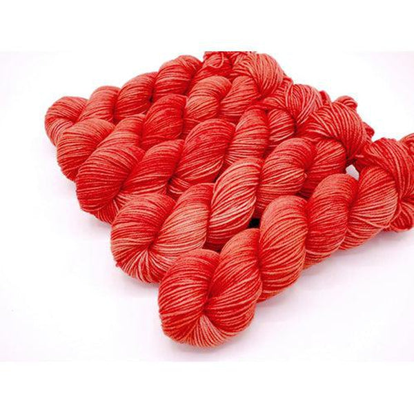 Skeins of Murky Depths Neptune DK Collins Ave, a tonally variegated yarn in shades of coral orange. 