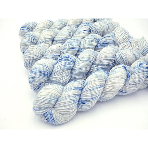 Skeins of Murky Depths Neptune DK Delft, a speckled yarn with shades of white and china blue. 
